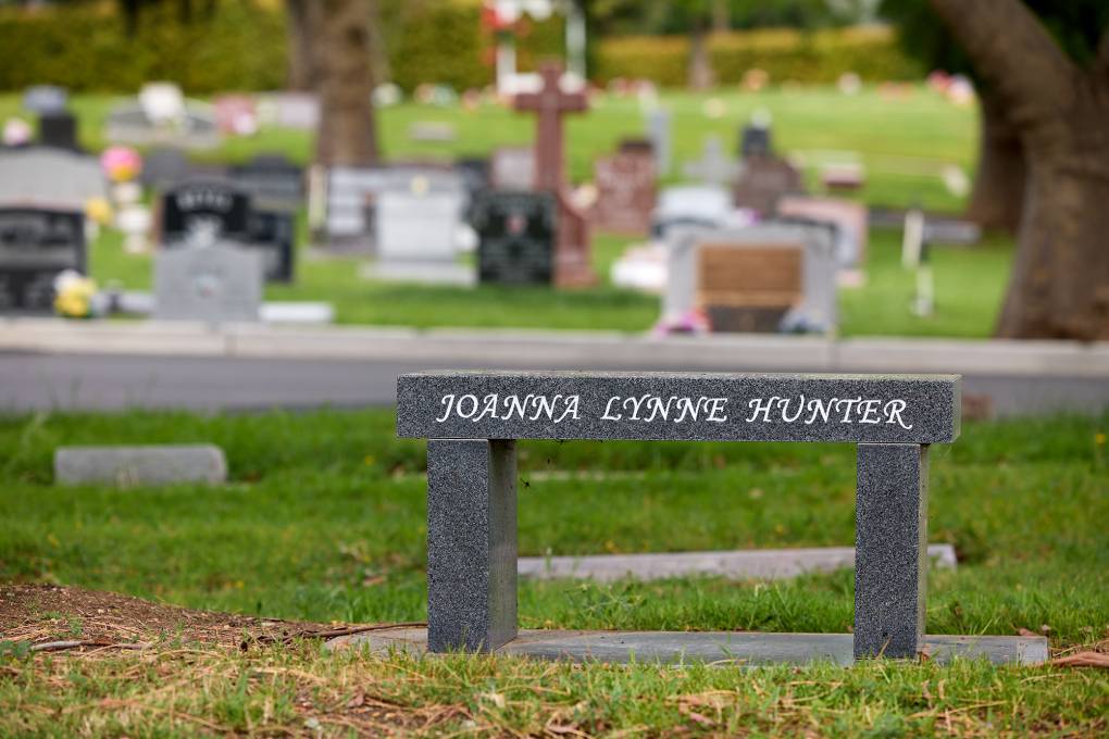 A memorial bench in a cemetery for Joanna Lynne Lewis.
