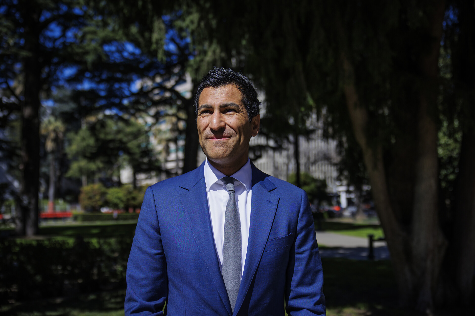 A man stands outside in a blue business suit.