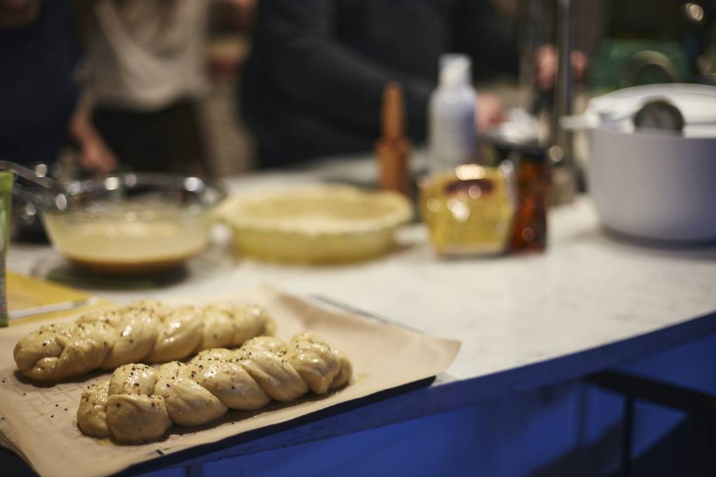 Bread being baked on a table with other dishes in the background.
