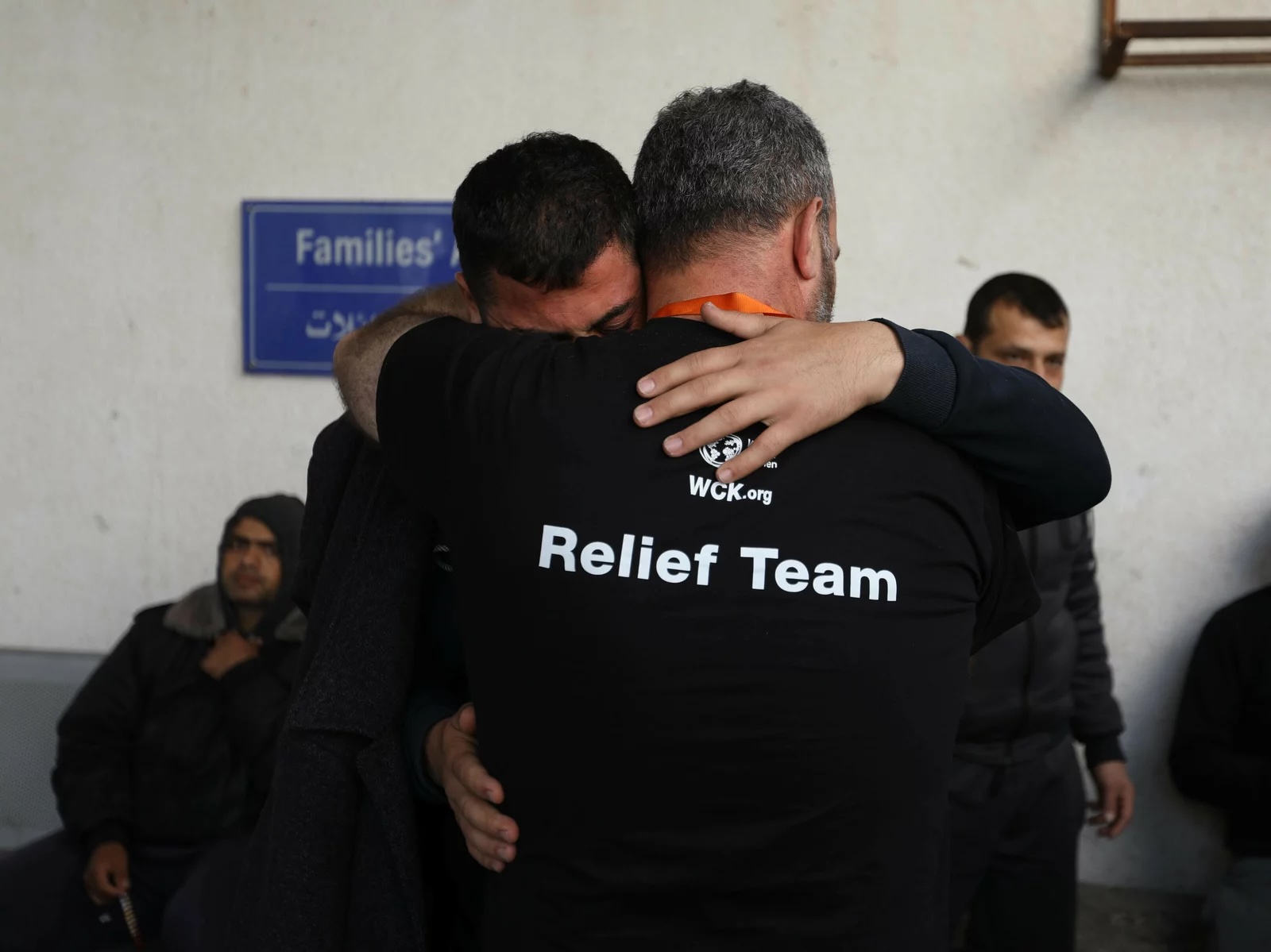 Two men are hugging, one man's shirt reads "Relief Team."