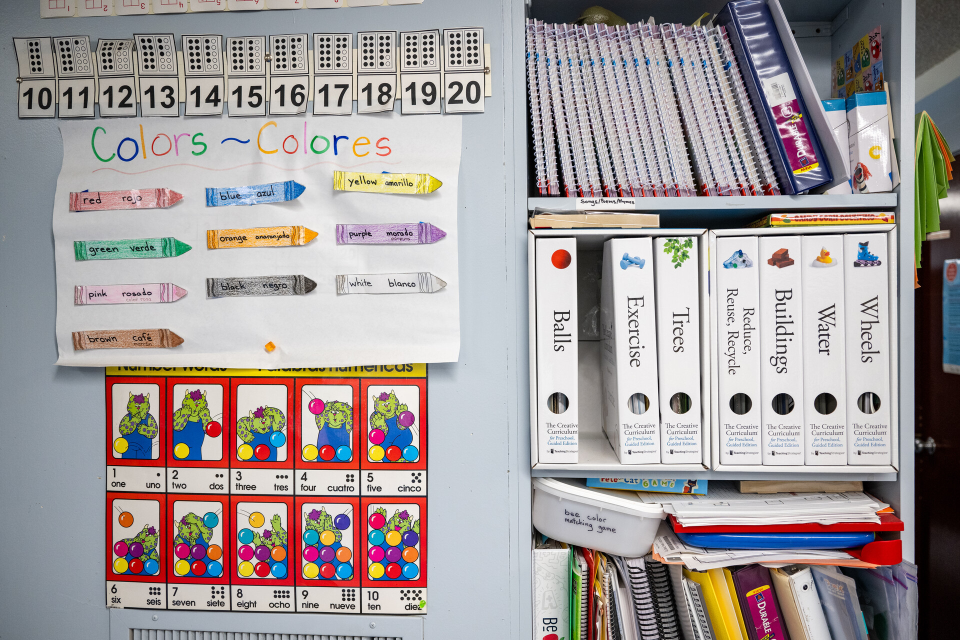 Bilingual classroom materials hang on a wall.