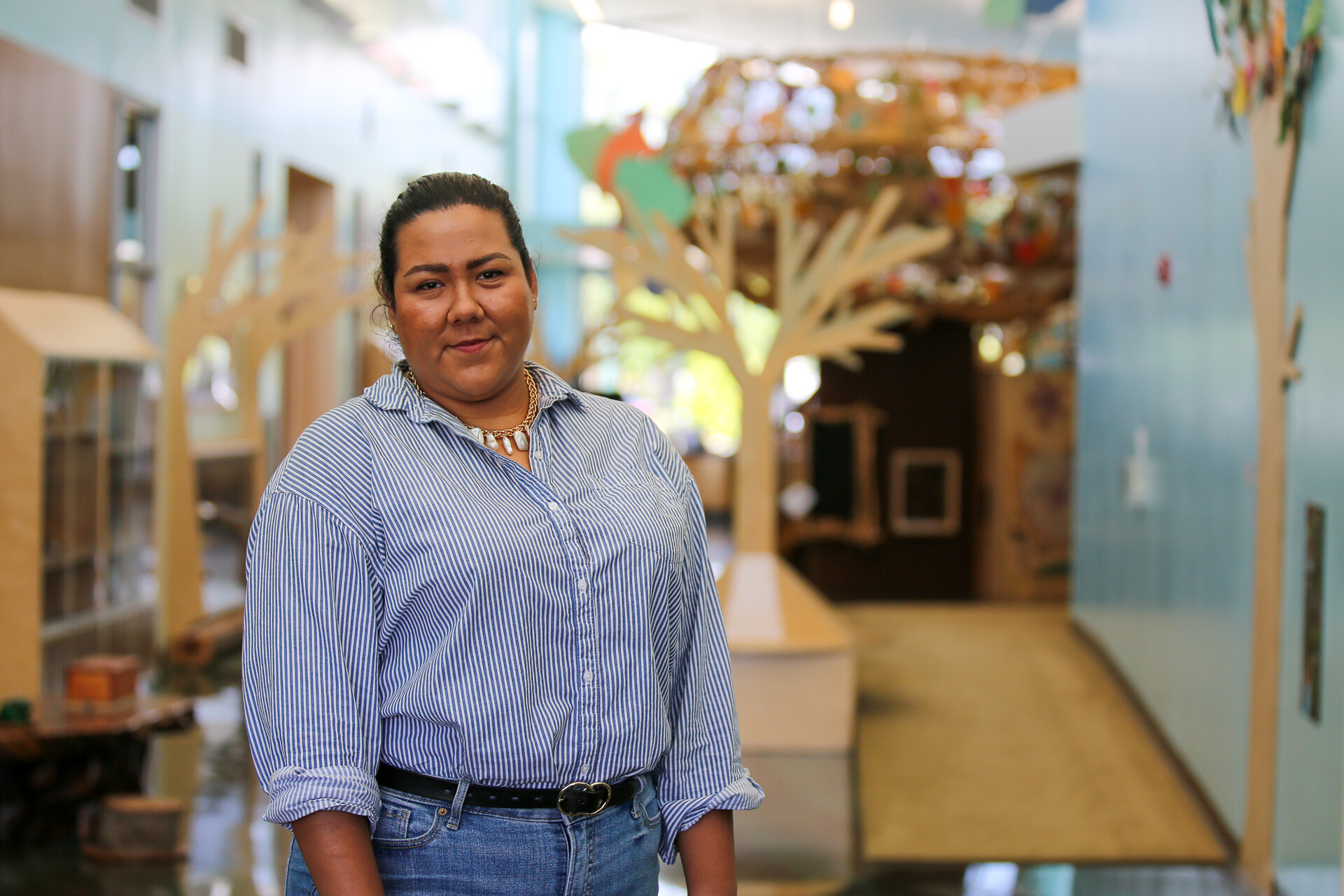 A Latina woman stands inside a community center.