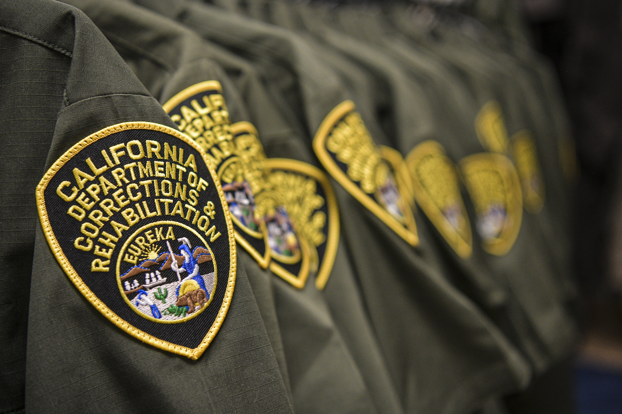 A row of arm patches that read "alifornia Department of Corrections and Rehabilitation."