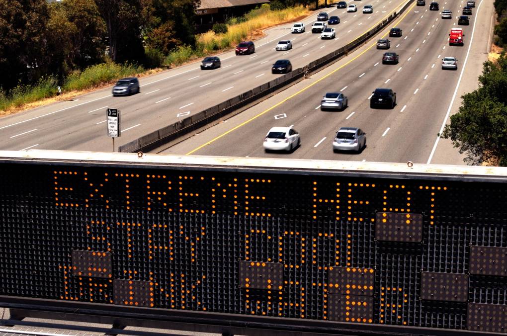 An electronic sign over a freeway stating, "Extreme Heat, Stay Cool, Drink Water"