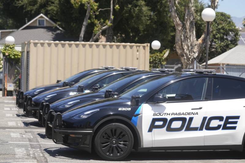 Teslas are labeled as police cars that are parked in a row.