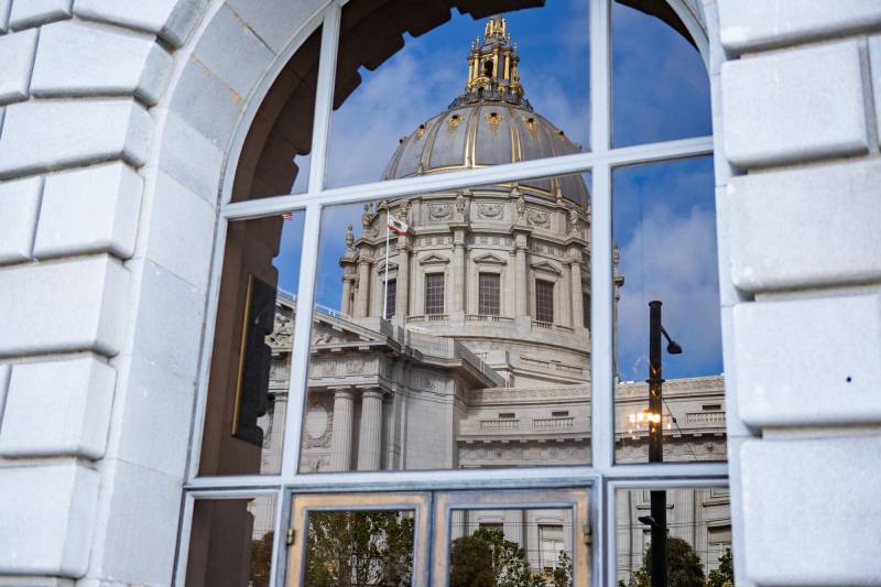 San Francisco's domed City Hall is reflected in the windows of the neighboring Veteran's Building