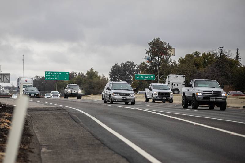 Cars drive on a highway.