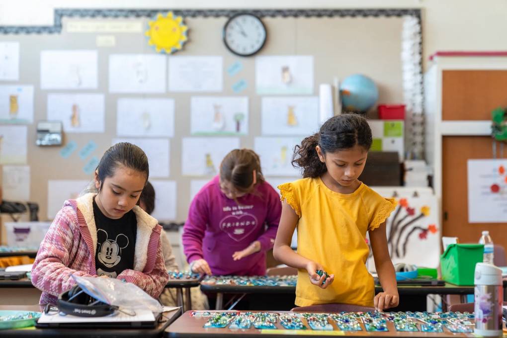 Young children work on projects in an elementary school classroom.