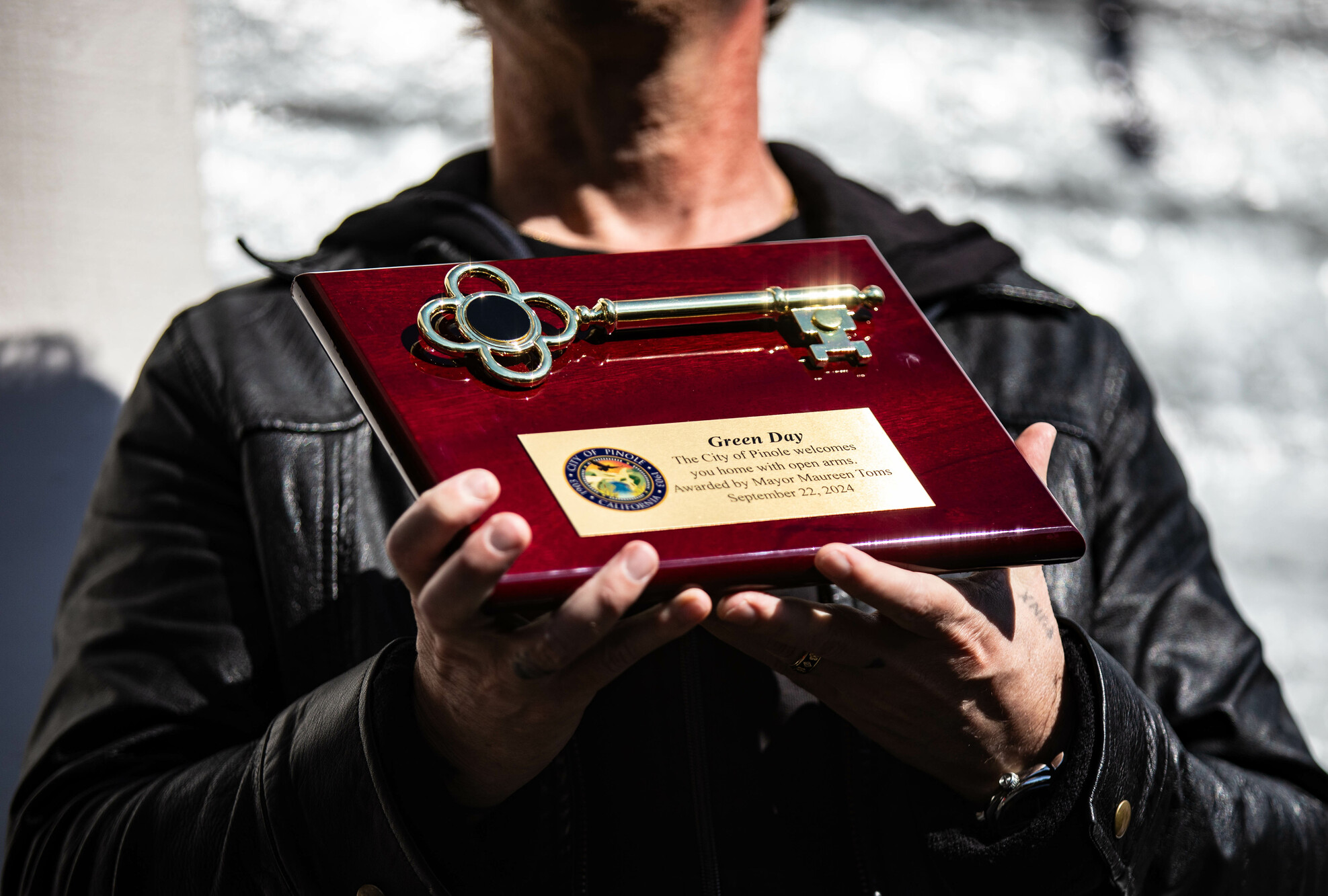 A man holds a plaque with a key on it.