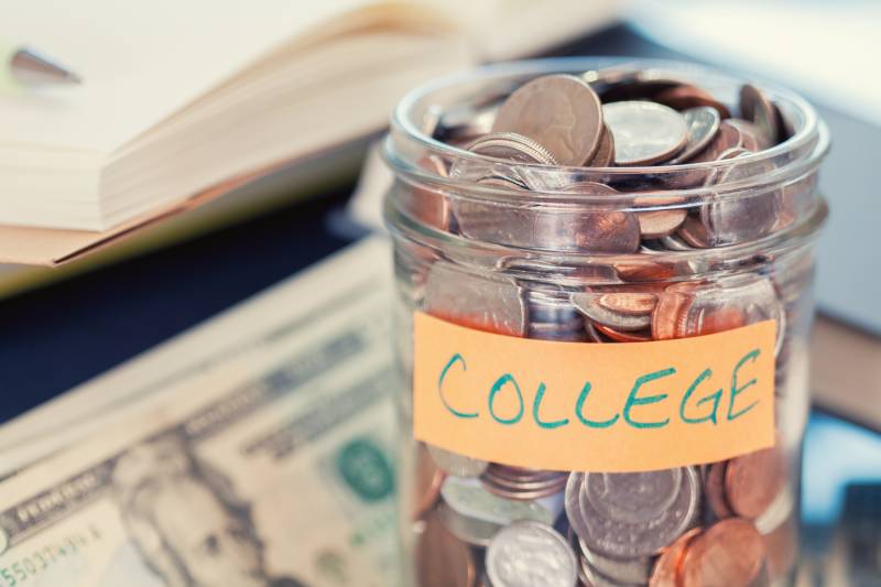 A glass jar full of change labeled 'College.'