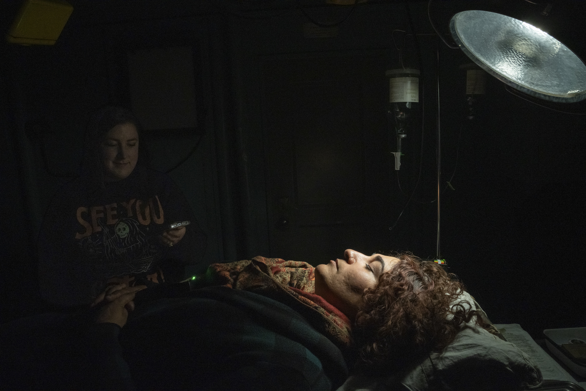 A woman lying down under a lamp.