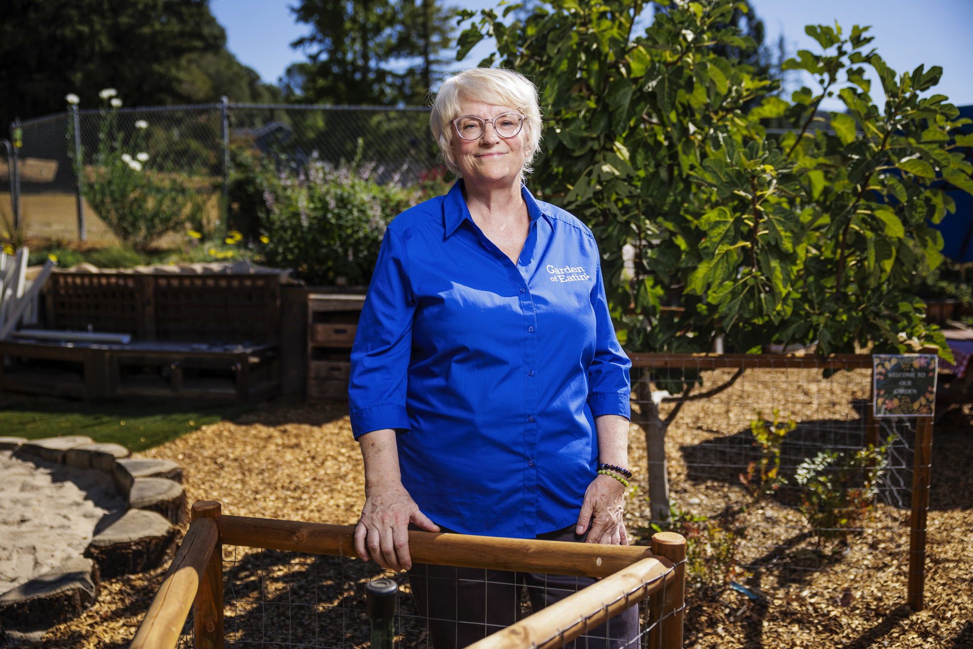 A middle-aged woman standing in a garden.