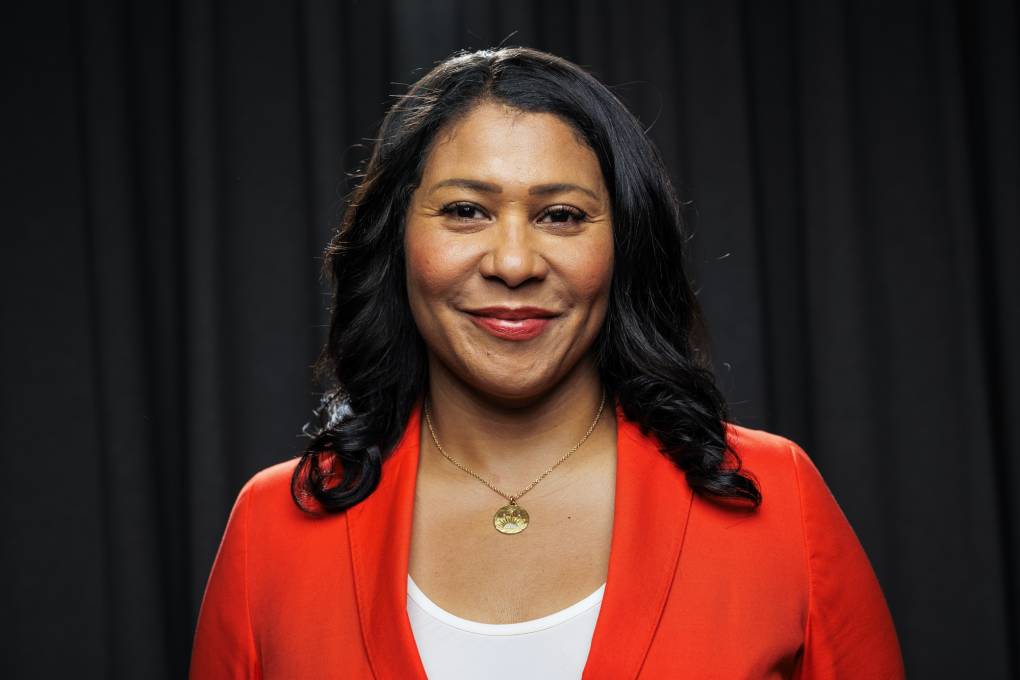 A Black woman wearing a red jacket and white shirt.