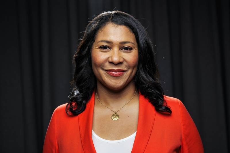 A Black woman wearing a red jacket and white shirt.