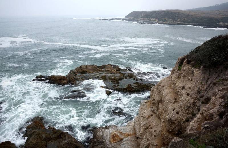 Waves crashing against rocks on a coastline.