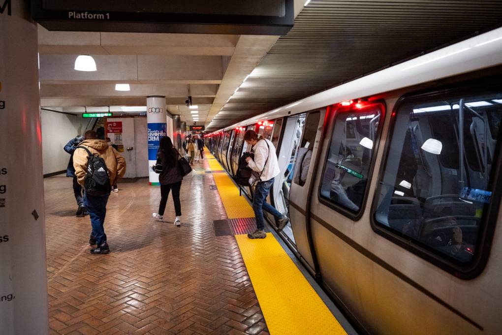 People get out of the train as it stops at a platform.