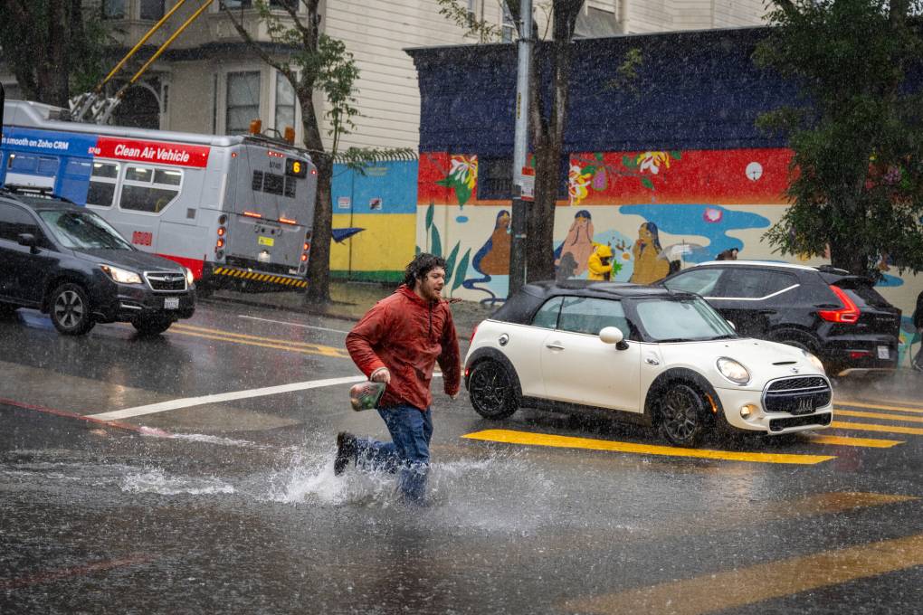 A man runs through a flooded road.