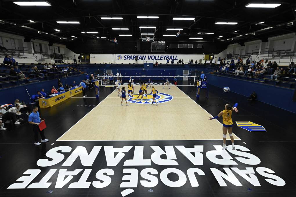 Inside of a gym with players in yellow uniforms.