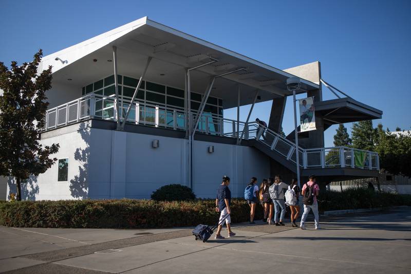 Several students walk in front of a university building.