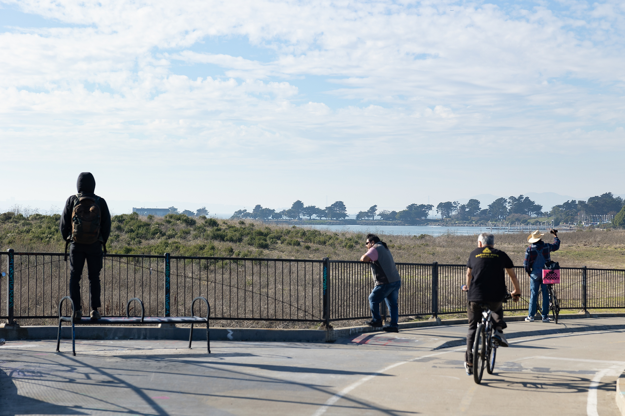 People look out over a railing into an open space.