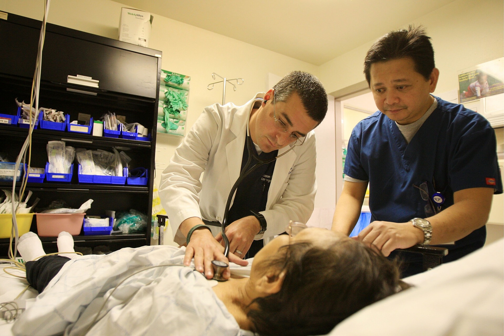 A doctor and nurse check a patient.