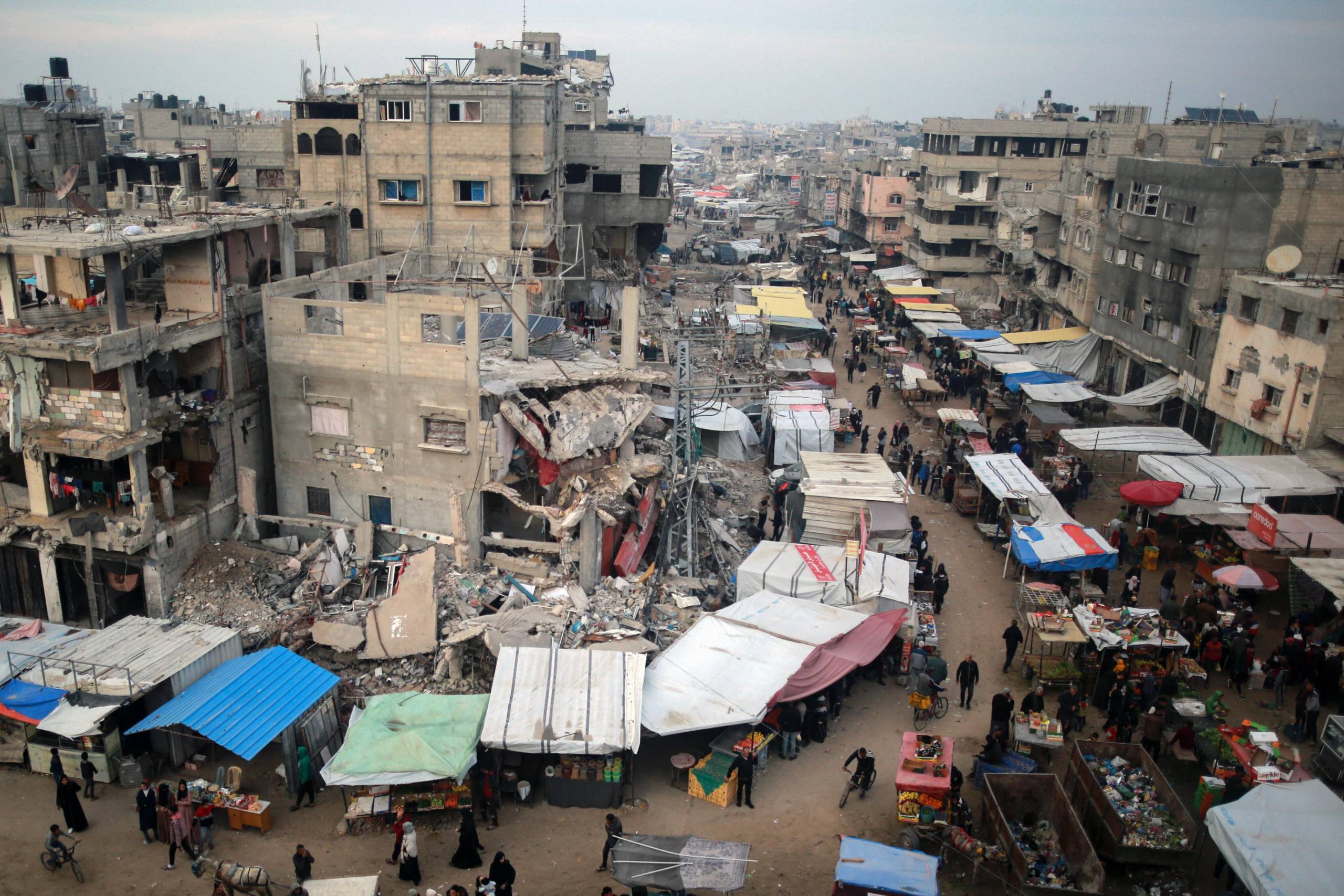 An outdoor market in a bomb-ravaged city.