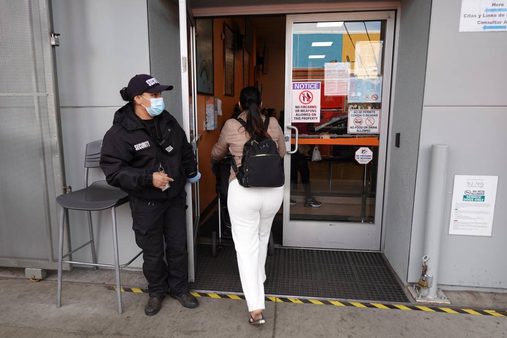 A security guard stands in front of the St. John’s Community Health clinic in South Los Angeles.