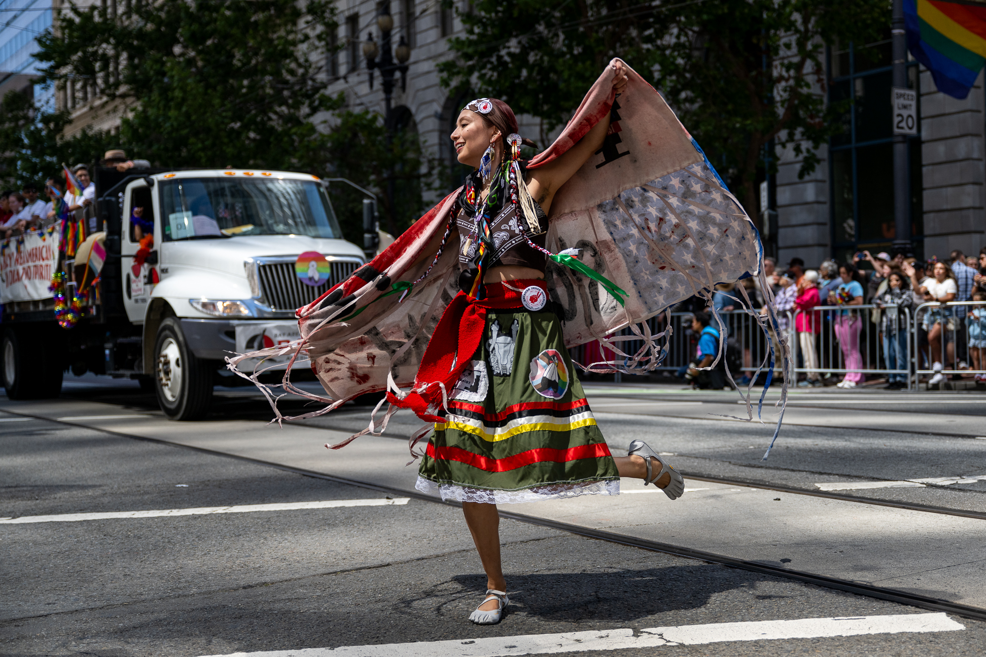 Uma pessoa que usava danças de roupas indígenas multicoloridas na rua.