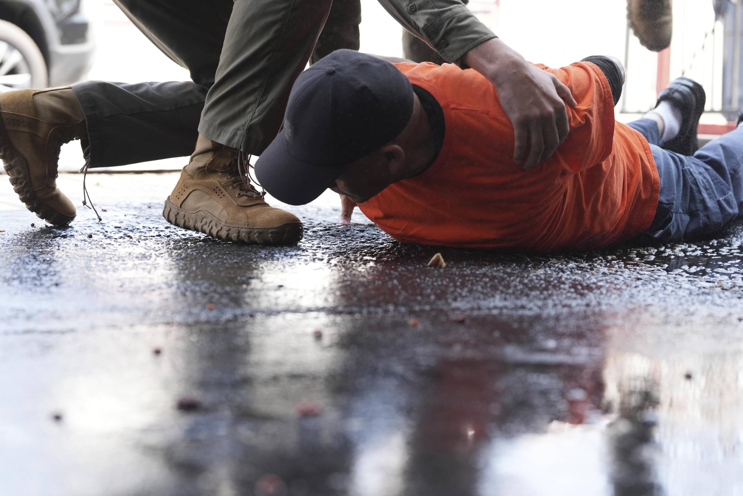 A man is detained by immigration agents at a car wash on Friday, Aug. 15, 2025, in Montebello, Calif.