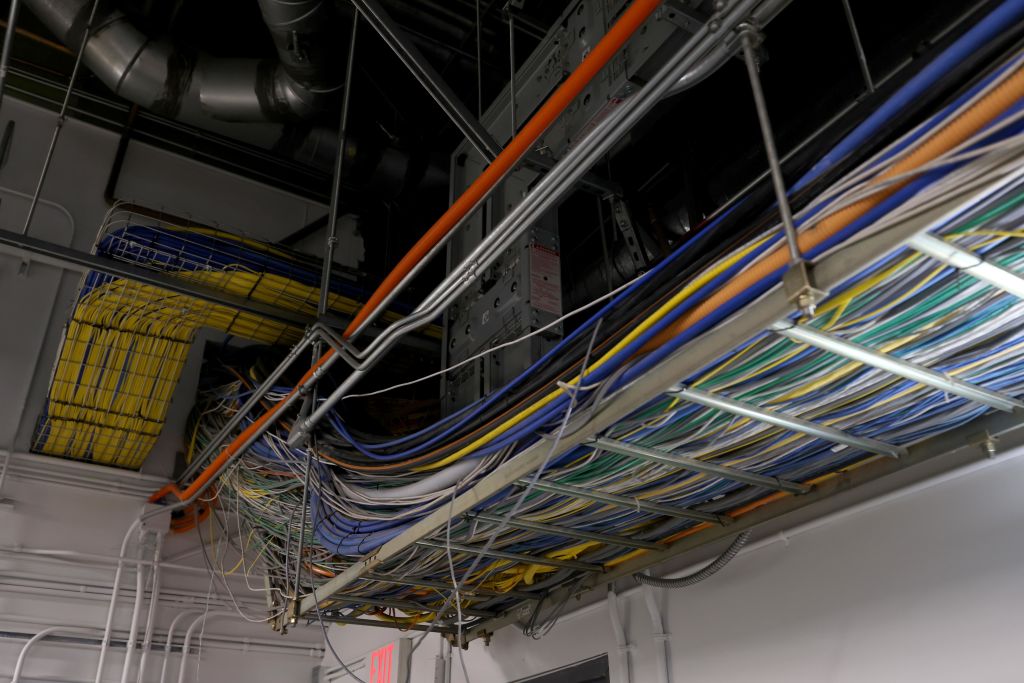A panel of multiple wires of different colors inside an office building.