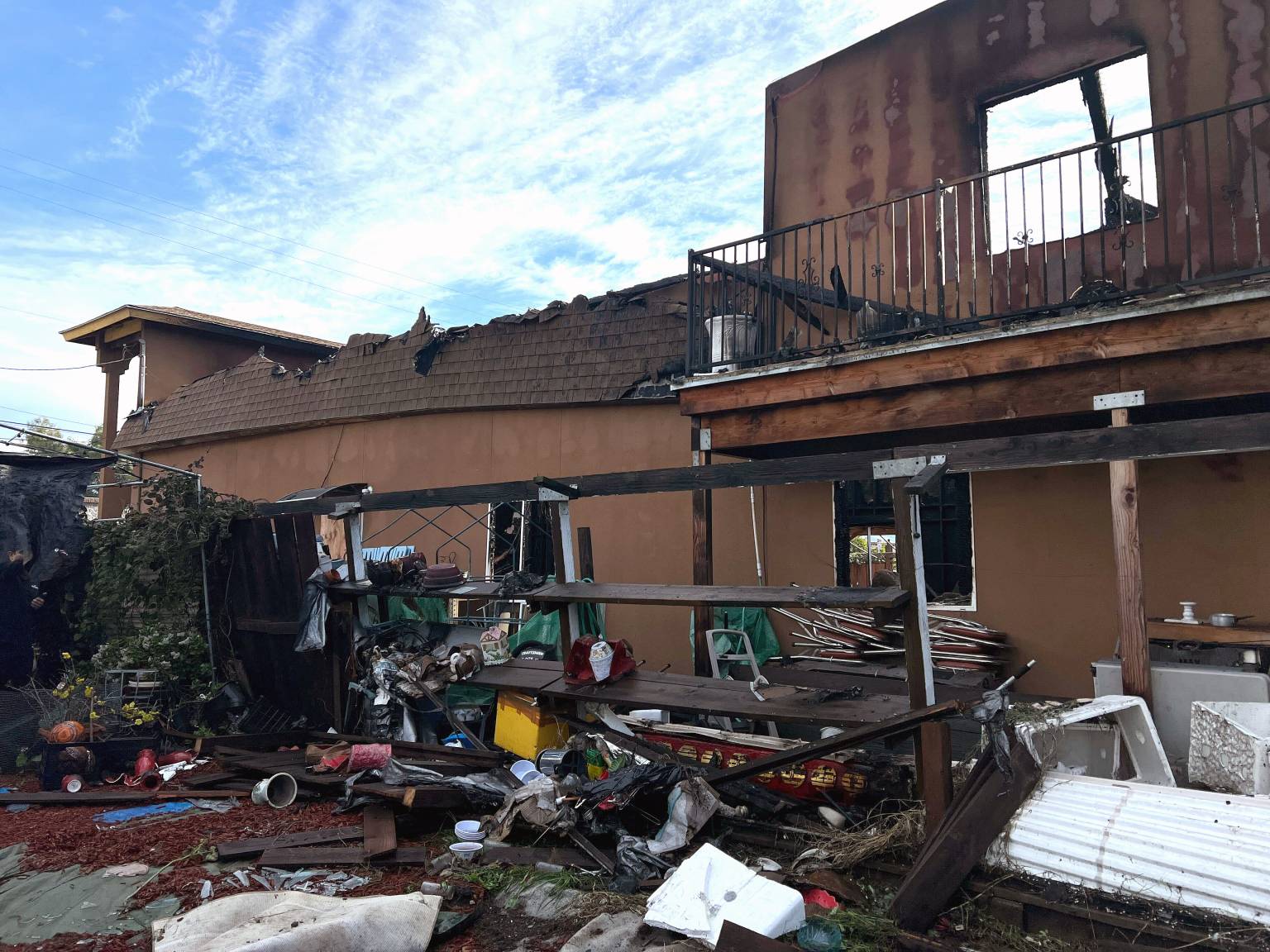 The debris of a shared fence and temple shelving lie scattered in David Ho’s backyard in San José on Jan. 5, 2026