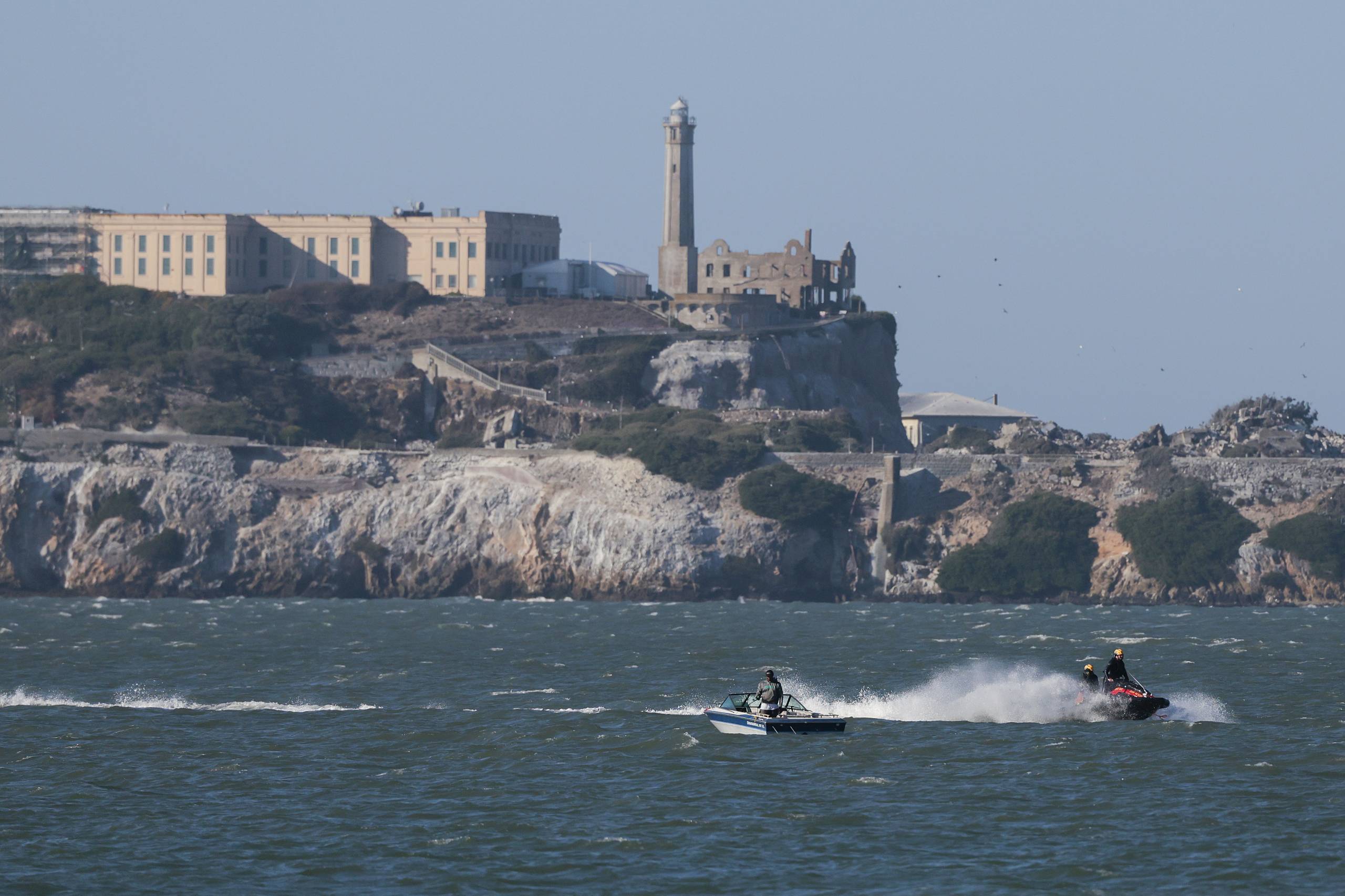 A jet ski and a boat off the coast of an island