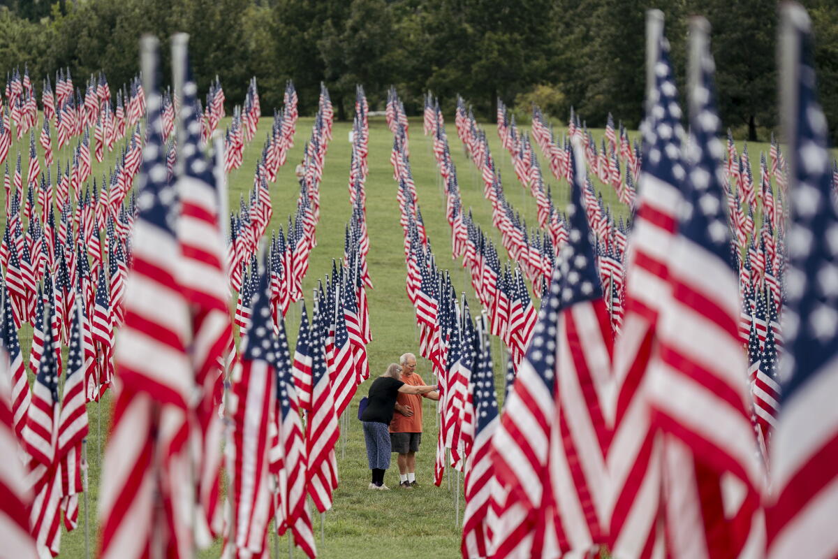 Darlene Johnson and David Johnson, both of Florissant, Mo., look over one of the flags at the 'Flags of Valor' installation on Thursday, Sept. 10, 2026, at Art Hill in Forest Park, St. Louis.