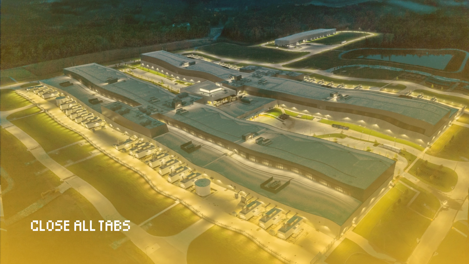 An overhead image of an AI data center, which is a gray building made of two long sections running parallel to each other, connected by a smaller structure in the middle — forming an “H” shape as a whole. Between the two longer sections and immediately surrounding the building are stretches of concrete sidewalk and patches of grass. Behind the main building, in the top right corner of the image, is a smaller elongated building and a large reservoir of water to its right. Both buildings are lit up by several lights and the whole data center is surrounded by a forest. The bottom three-quarters of the image are slightly warped and have an ombre, urine-colored yellow tint. The text "Close All Tabs" appears in white text in the lower left corner.