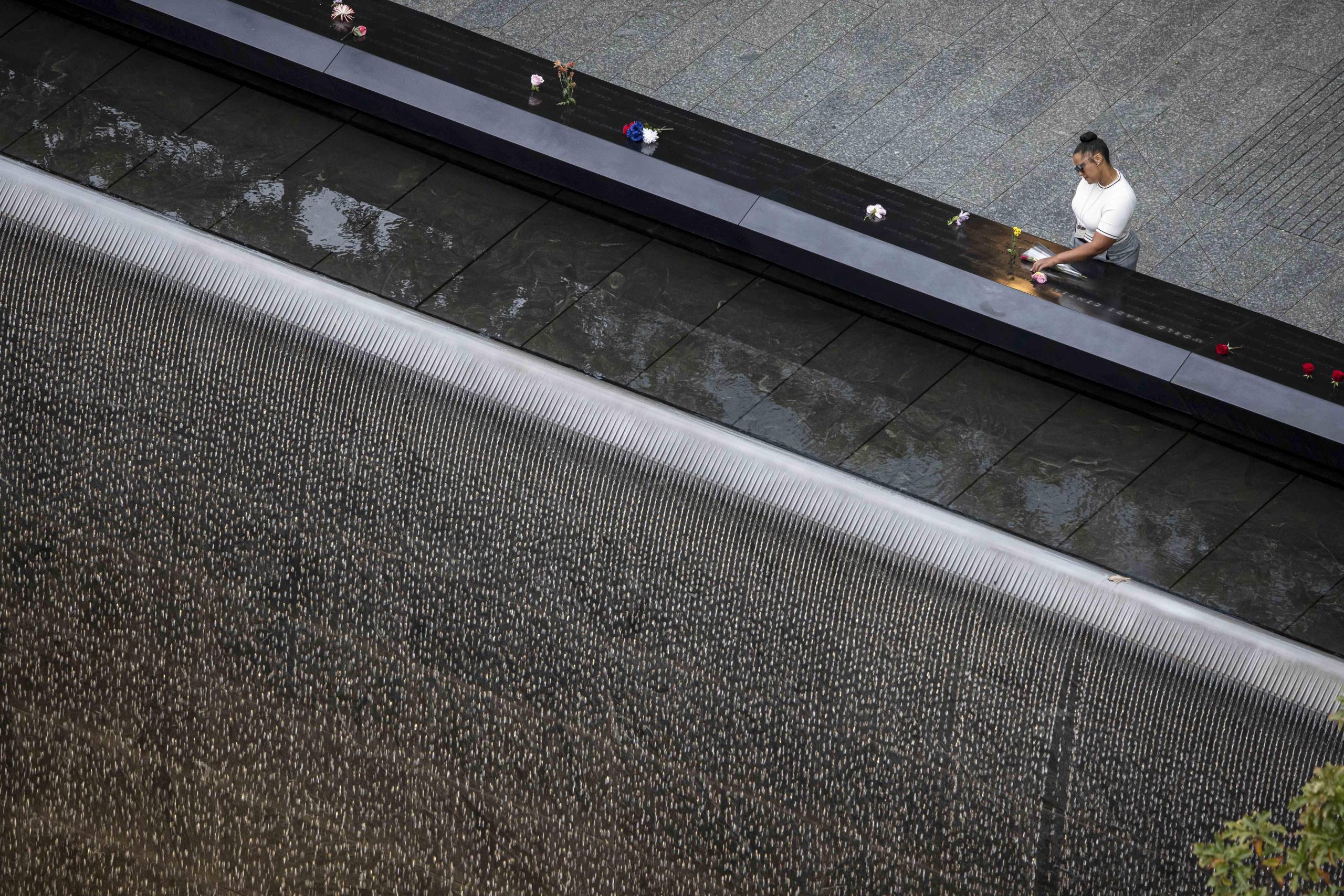 A woman places flowers at the September 11 memorial plaza in Lower Manhattan ahead of a ceremony commemorating the 25th anniversary of the Sept. 11, 2001, attacks at the National September 11 Memorial in New York on Friday.