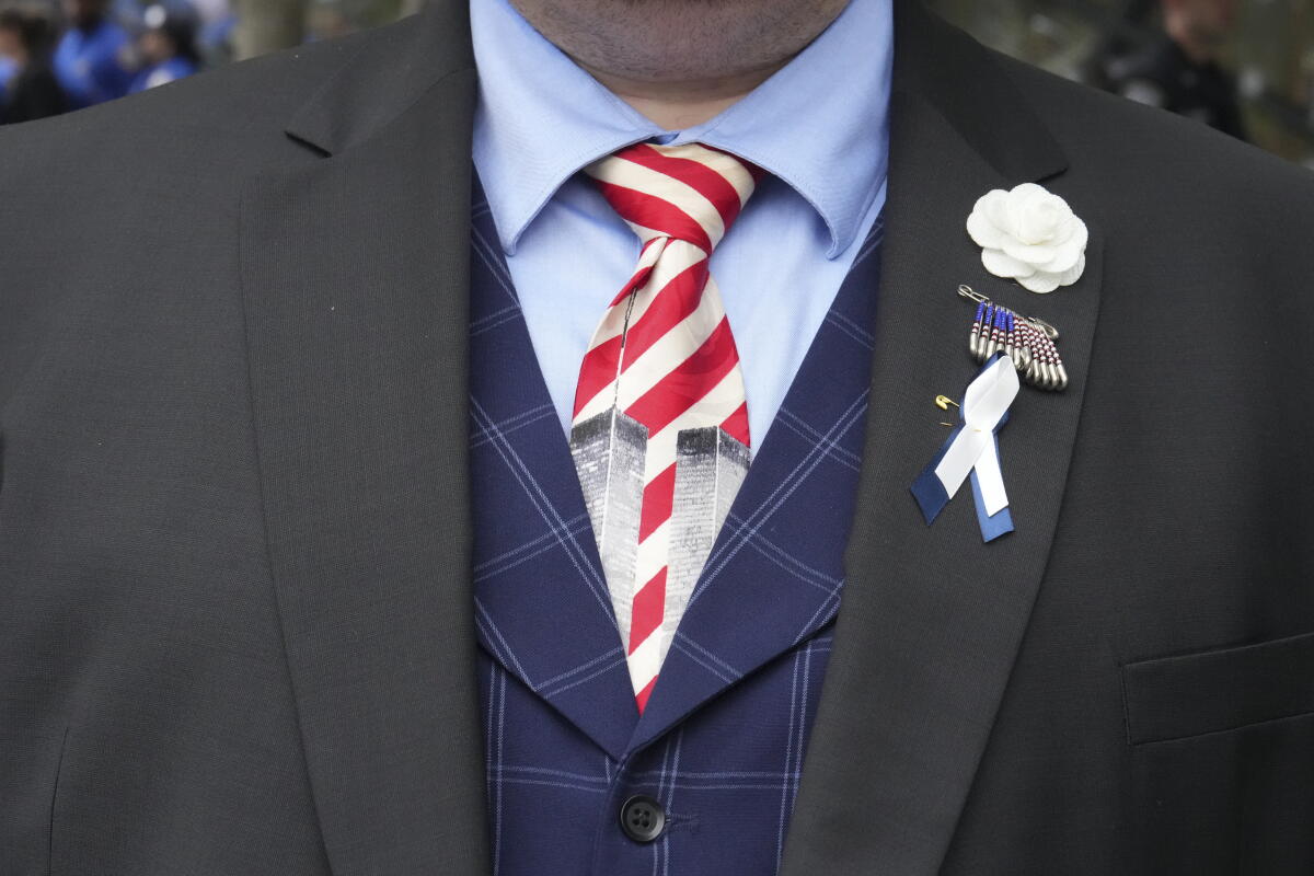 A man wearing a tie depicting the Twin Towers stands ahead of a memorial ceremony to commemorate the 25th anniversary of the September 11th terrorist attacks on the World Trade Center at the National 9/11 Memorial & Museum on Friday.