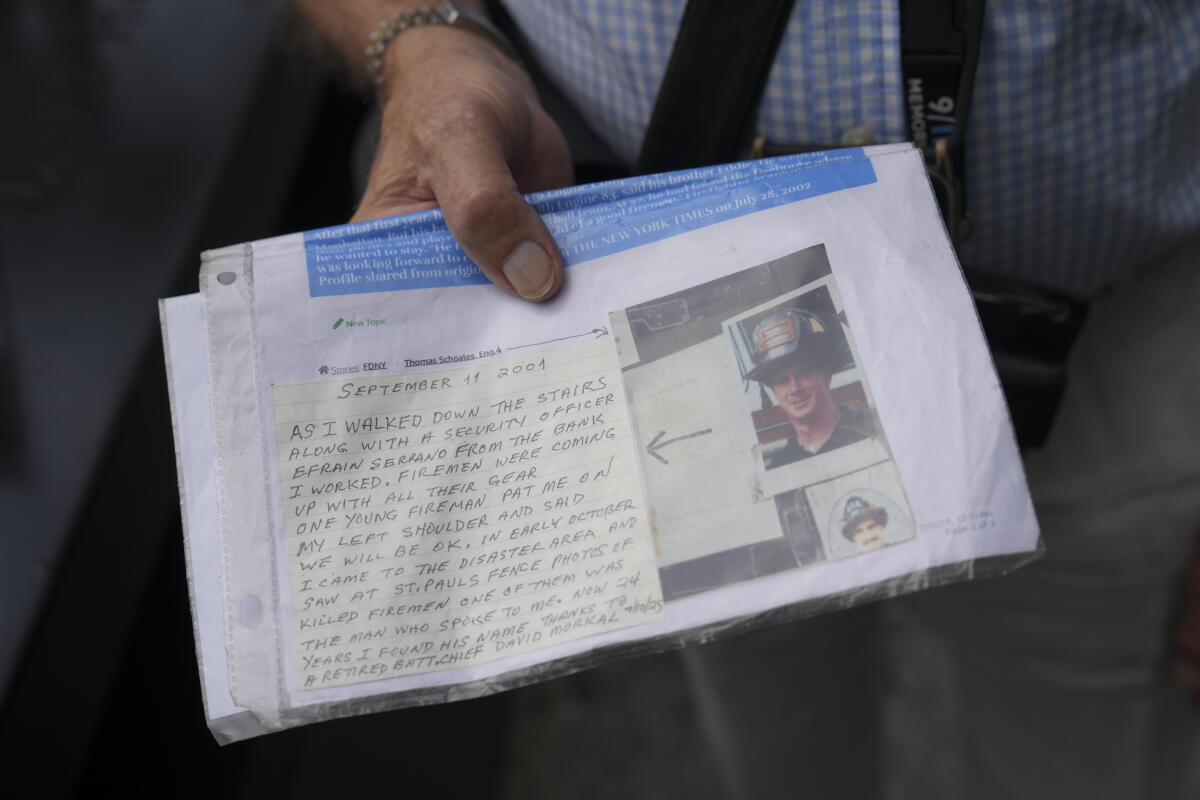 9/11 survivor George Mironis holds a photograph of a firefighter who died in the attacks and a note ahead of a memorial ceremony to commemorate the 25th anniversary of the September 11th terrorist attacks on the World Trade Center at the National 9/11 Memorial & Museum on September 11, 2026, in New York City.