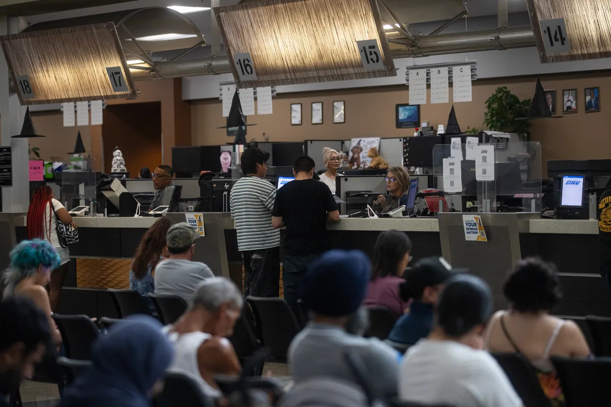 People stand at the counter of the Department of Motor Vehicles in Fresno on Oct. 2, 2026.