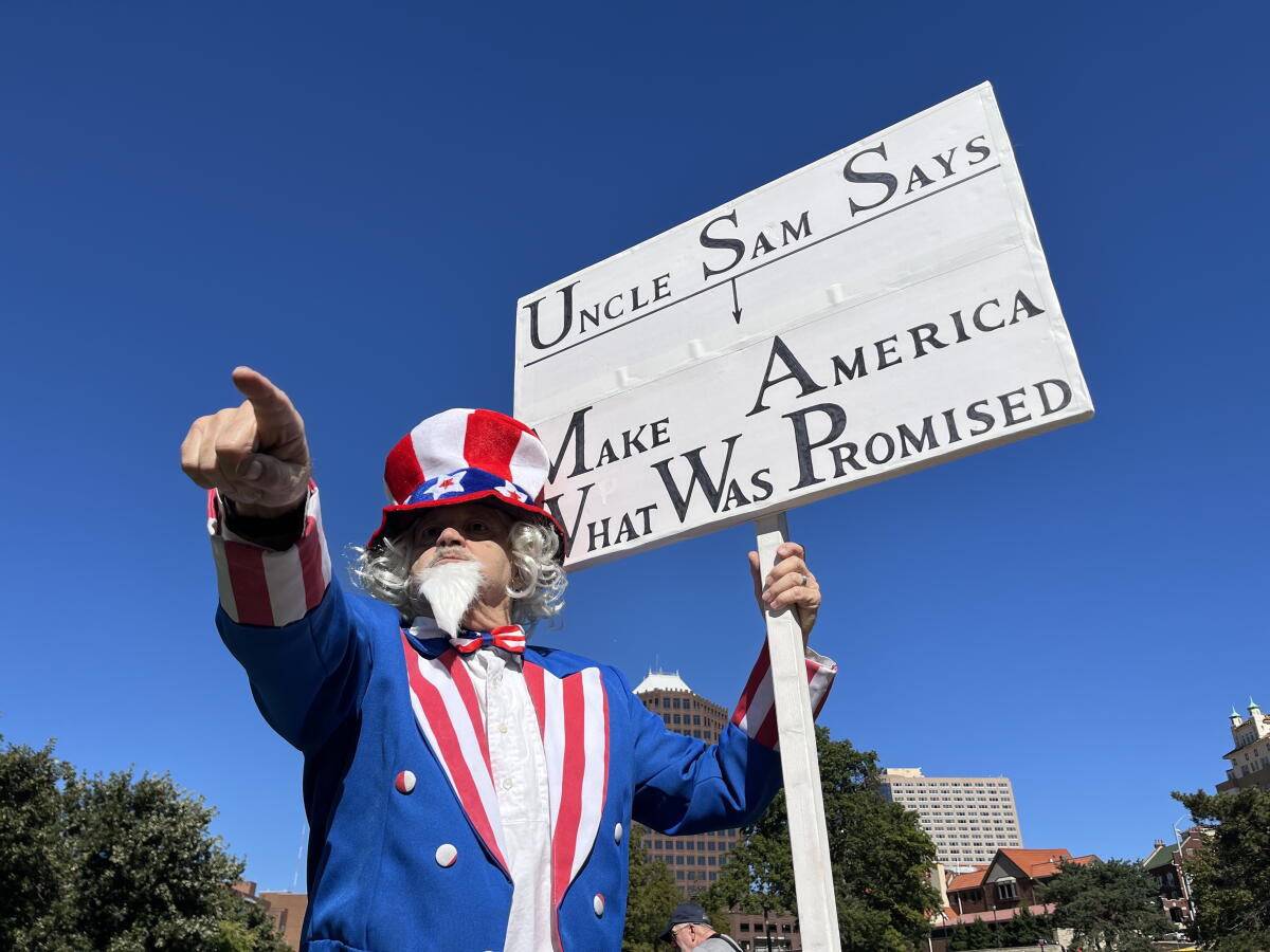 Alan Watkins, from Overland Park, Kan., dressed as Uncle Sam for a No Kings rally on Saturday, Oct. 17, at Mill Creek Park in Kansas City, Mo. The event was part of a nationwide day of action, with several gatherings planned across the metro.