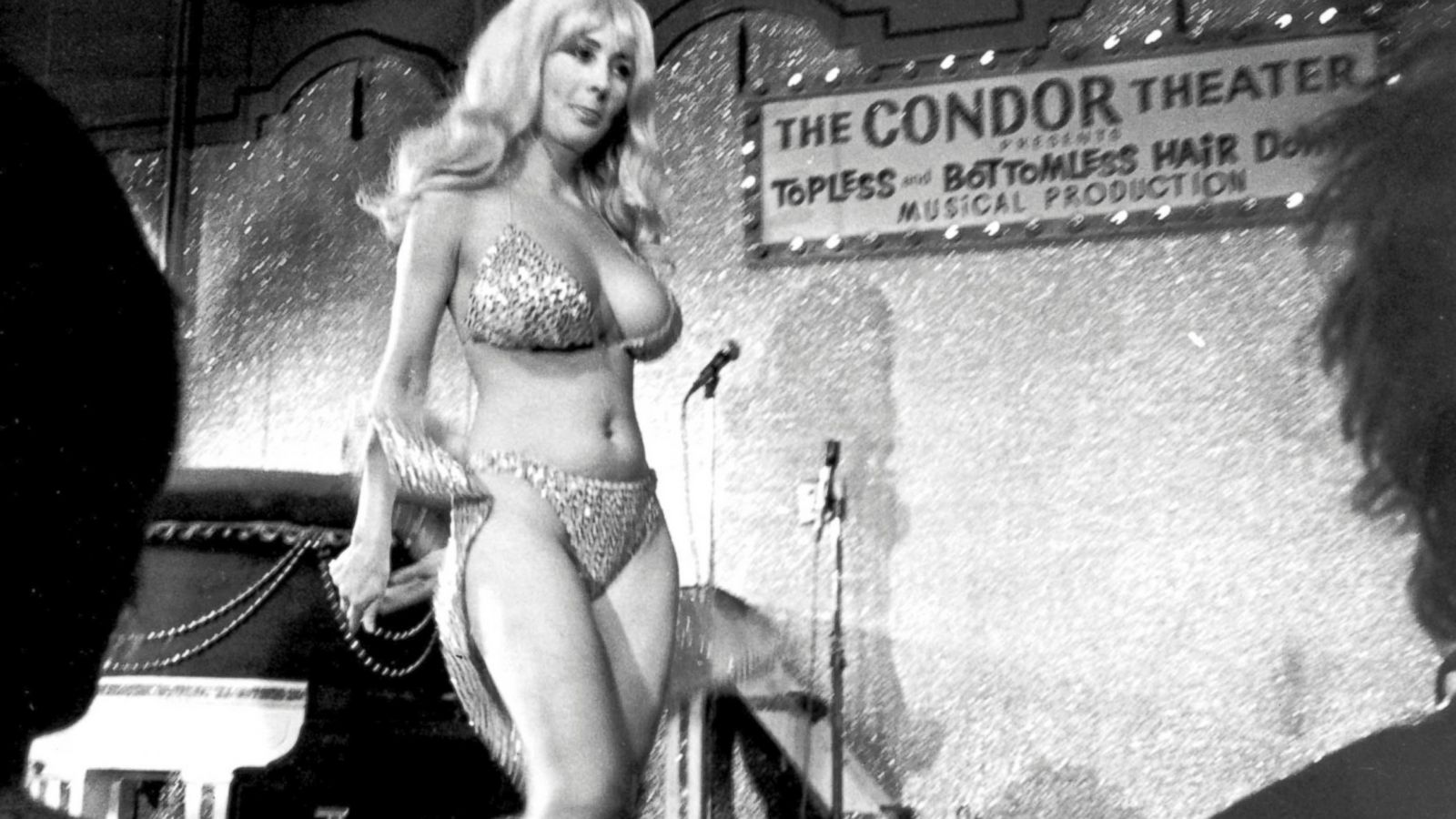 woman with long hair in spangly bikini dances on stage