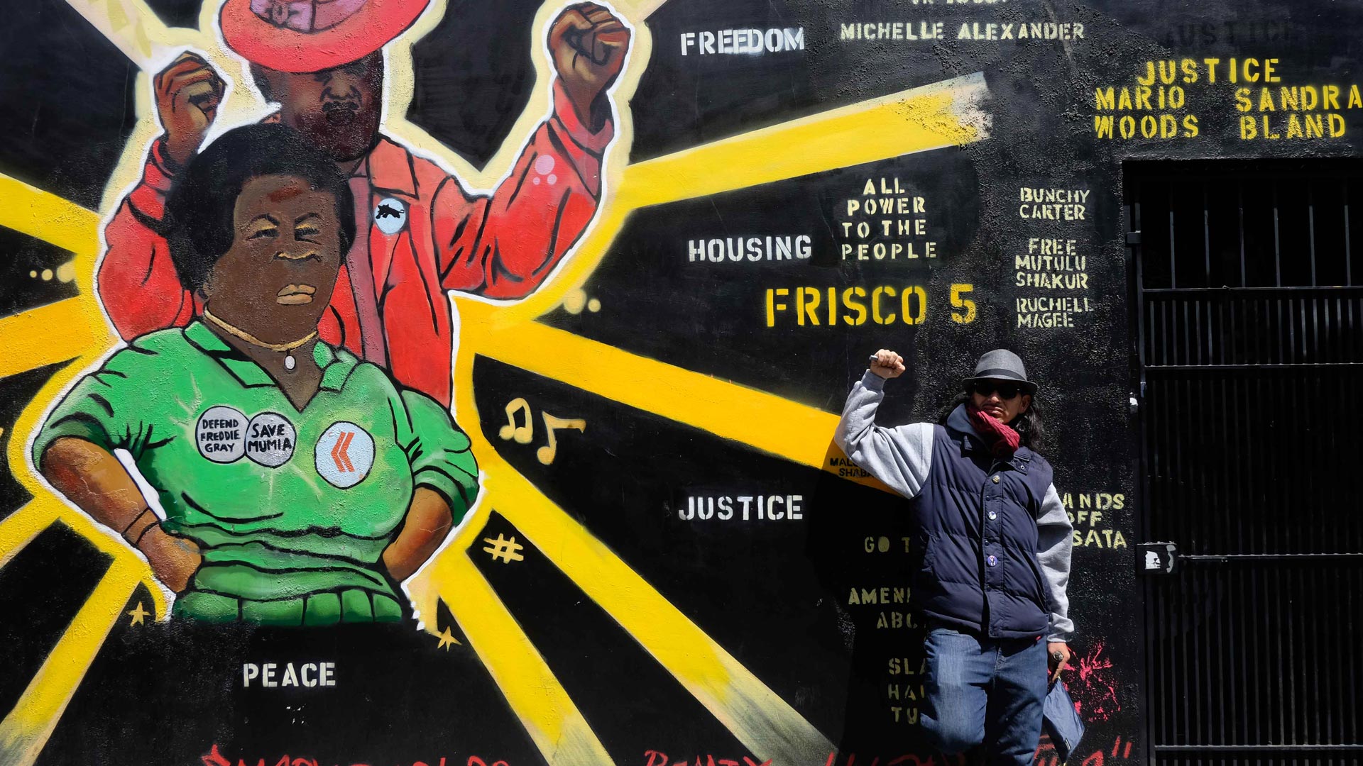 Equipto leans against a freshly painted mural dedicated to freedom fighters of the past and present.