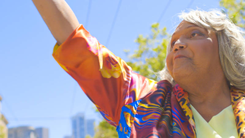 Miss Major waving to Pride Parade participants.