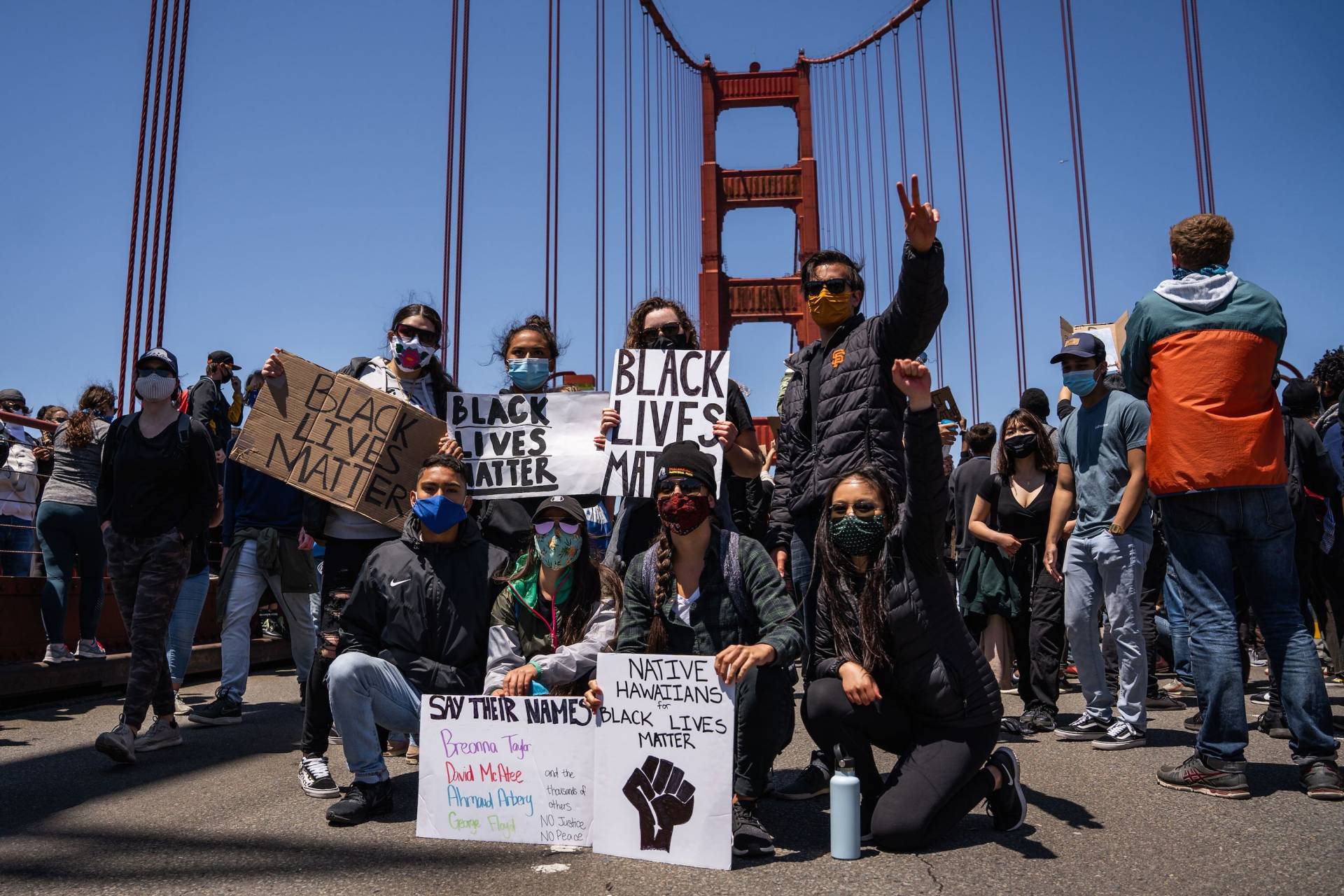 Protesters pose with Black Lives Matter signs on the Golden Gate Bridge during a demonstration against racism and police brutality in San Francisco, California, on June 6, 2020.