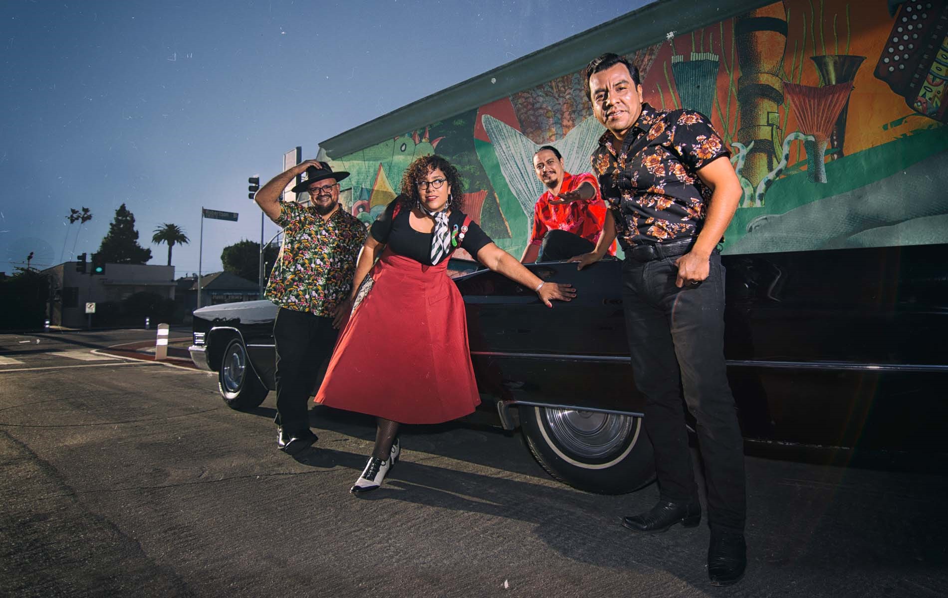 band photo alongside older car