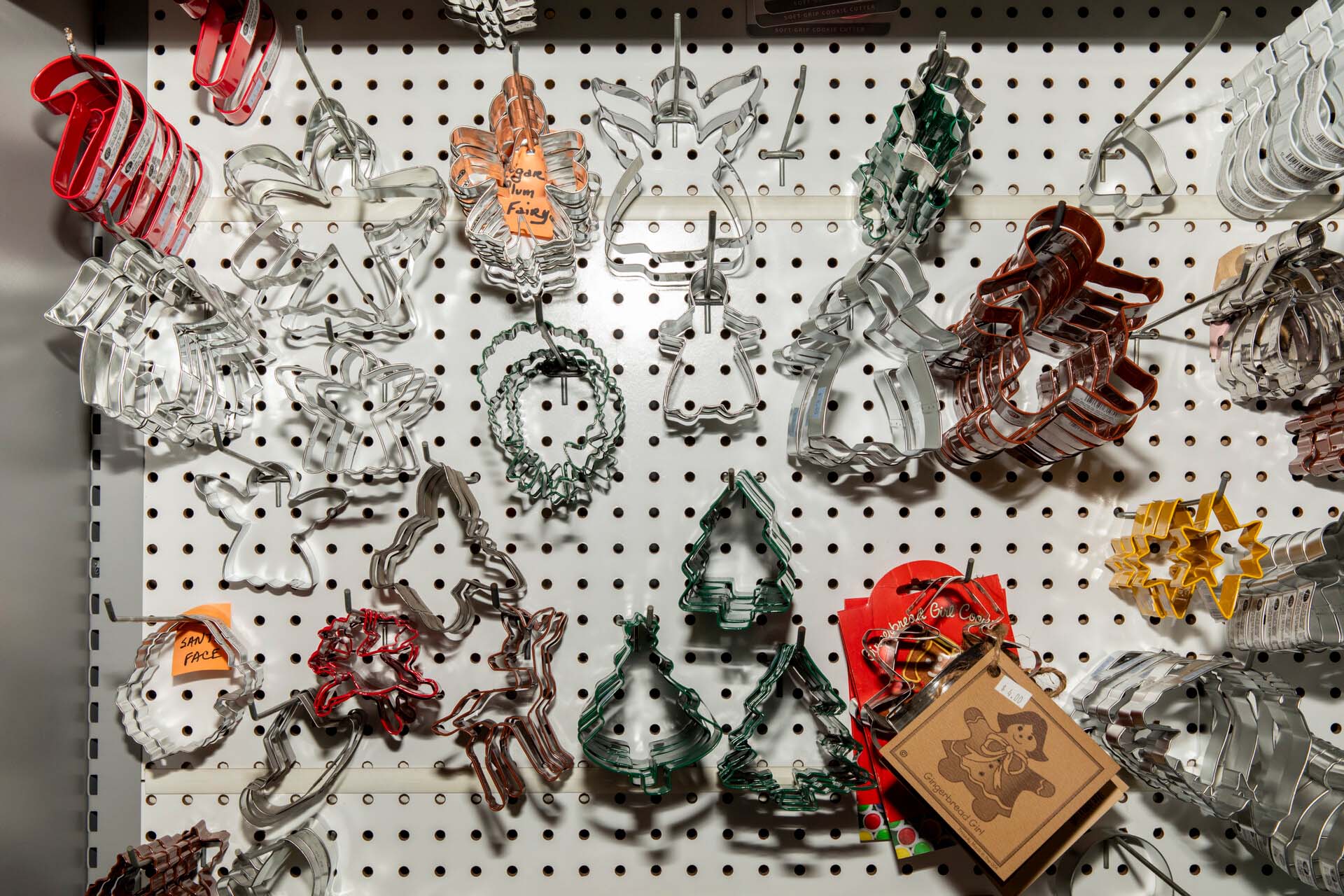 A display of holiday-themed cookie cutters hanging from hooks.