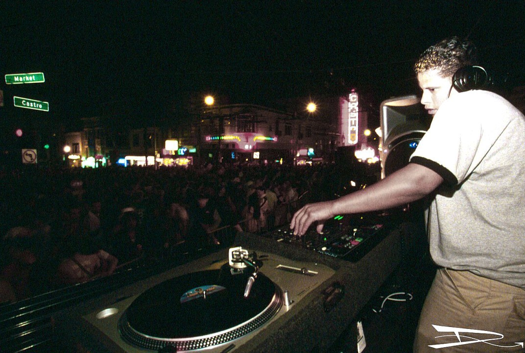 A DJ beat-matches two records on turntables. 