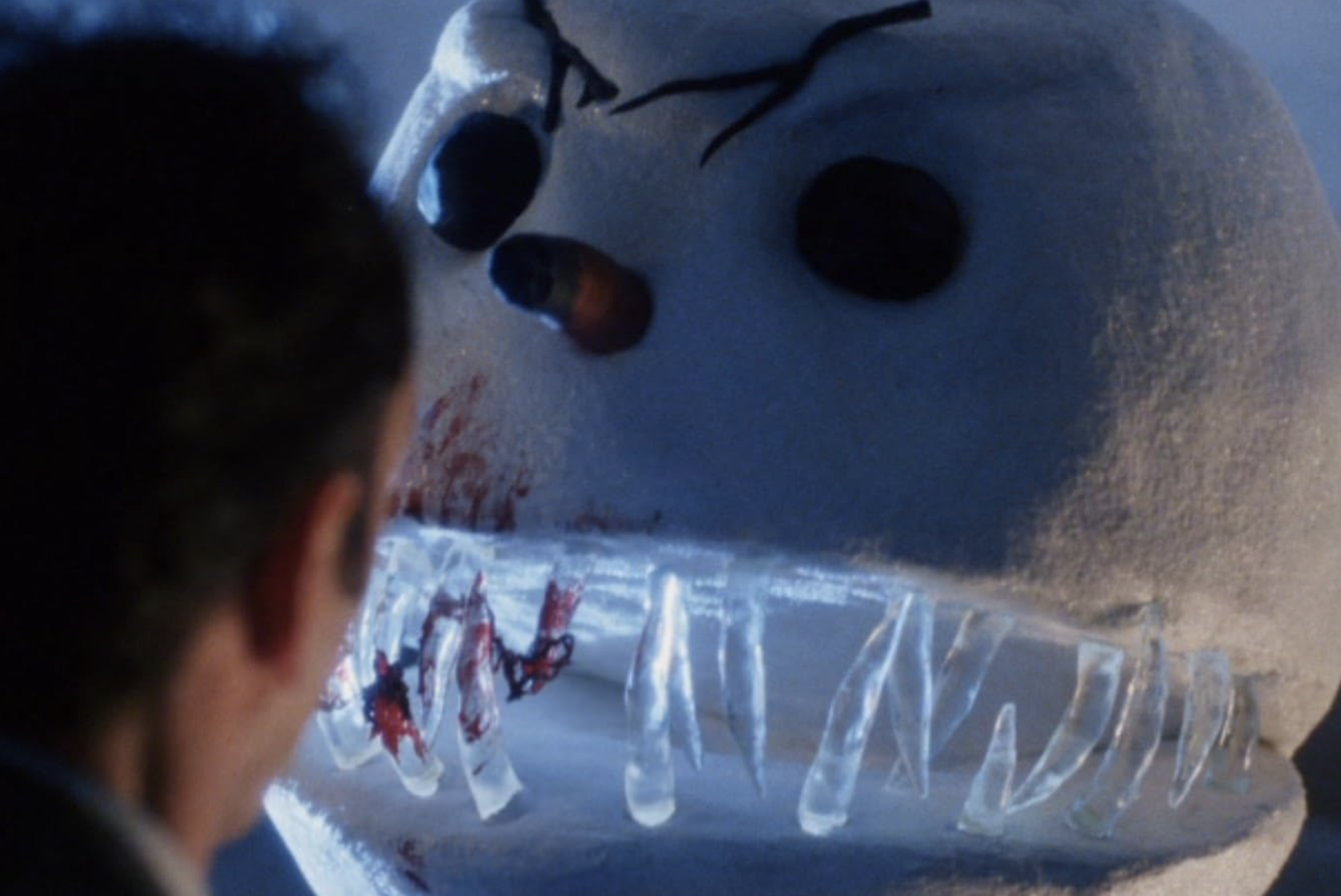 A snowman with twig eyebrows and icicle fangs interacts with a human.