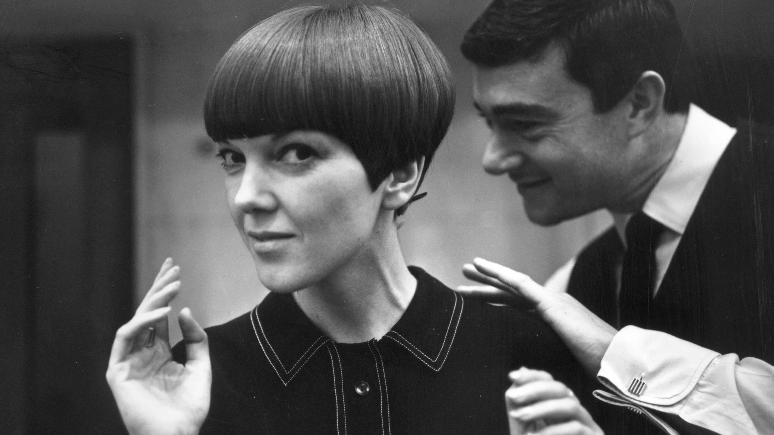 Black and white photo of woman with precise bob haircut in mod-style dress