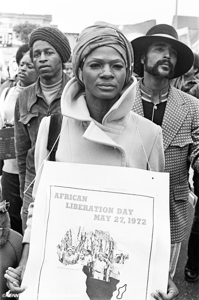A Black woman holds a sign that reads African Liberation Day May 27, 1972.