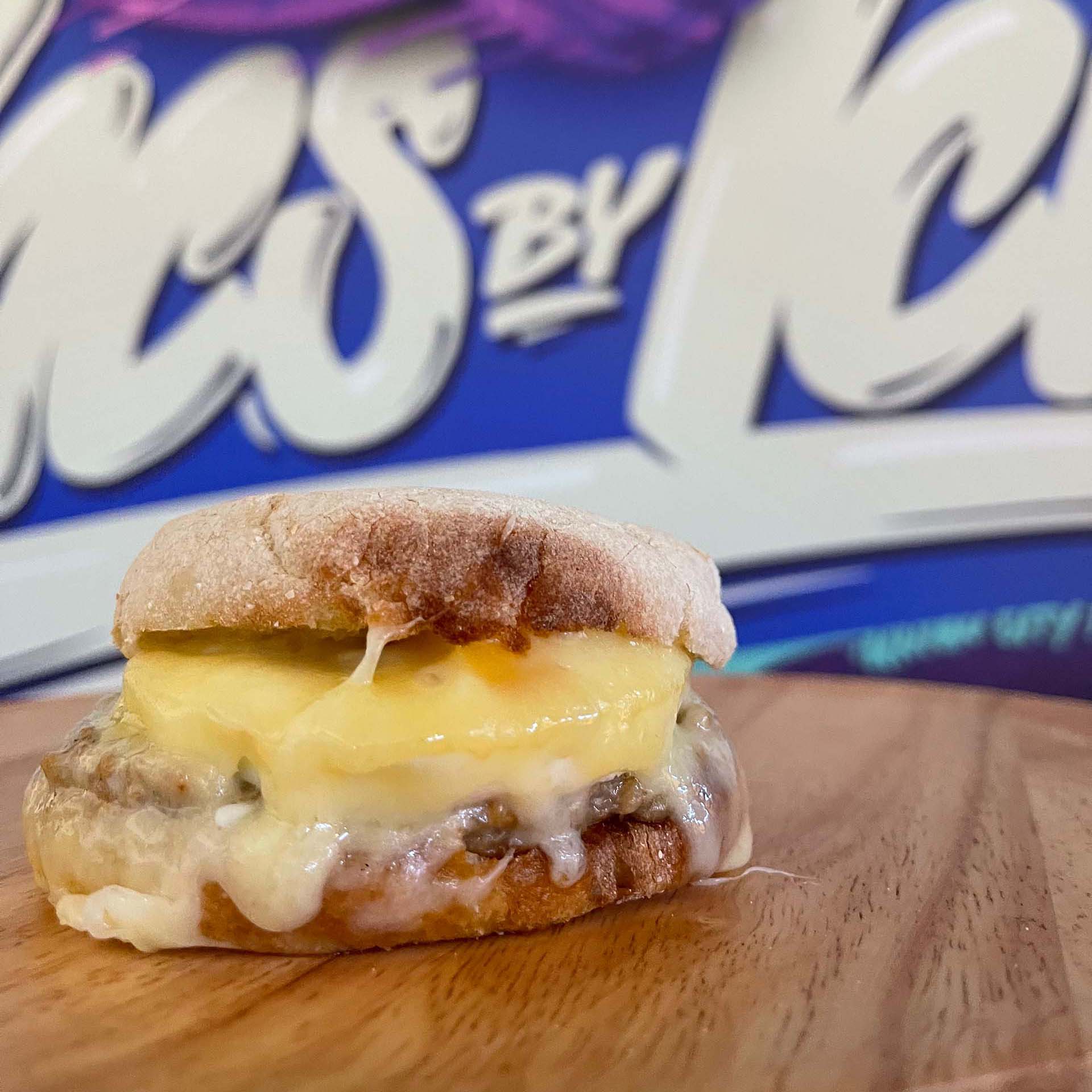 a breakfast sandwich with melting cheese displayed on a table
